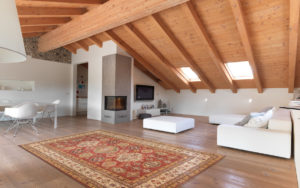 Tappeto classico rosso e beige con motivi floreali in un soggiorno con soffitto in legno