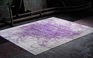 Tappeto moderno bianco con segni astratti viola e rosa in ambiente scuro