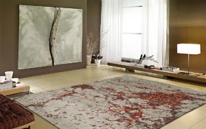 Tappeto moderno grigio chiaro con motivi classici rossi in un soggiorno luminoso