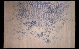 Dettaglio di tappeto moderno beige e blu con motivo geometrico