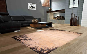 Tappeto moderno color pesca con bordi scuri effetto vissuto in un soggiorno contemporaneo