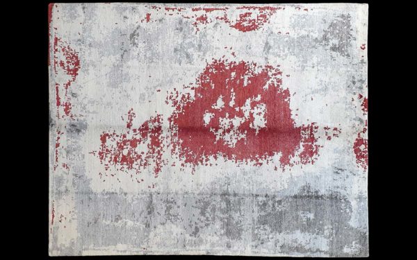Dettaglio di tappeto moderno astratto crema, rosso e grigio
