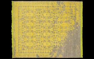 Dettaglio di tappeto moderno giallo e grigio con motivo classico destrutturato
