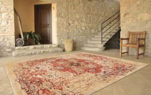 Tappeto moderno crema e rosso con motivo classico destrutturato in un interno rustico