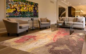 Tappeto moderno astratto crema, grigio, rosso e giallo in un soggiorno elegante