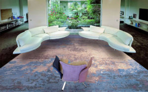 Tappeto moderno astratto blu e arancione in un soggiorno con divani bianchi