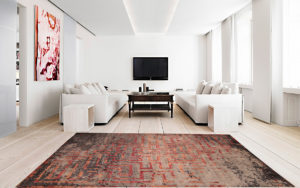 Tappeto moderno rosso, grigio e nero con motivo geometrico in un soggiorno luminoso