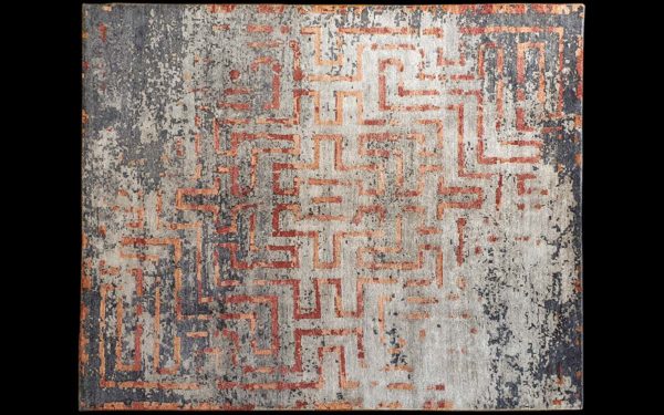 Dettaglio di tappeto moderno grigio e rosso con motivo geometrico a labirinto